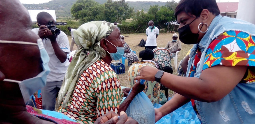 An elderly widow receives a pack of food relief from Dr. Andre Patrice Carter after a lunch meeting with the project beneficiaries